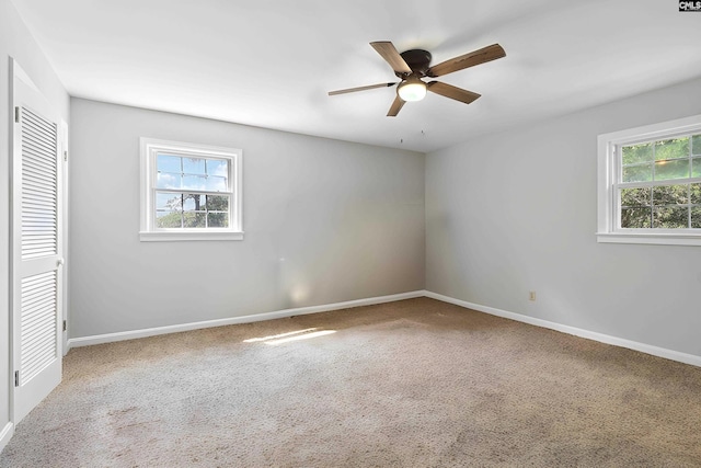 unfurnished bedroom featuring carpet flooring, multiple windows, and ceiling fan