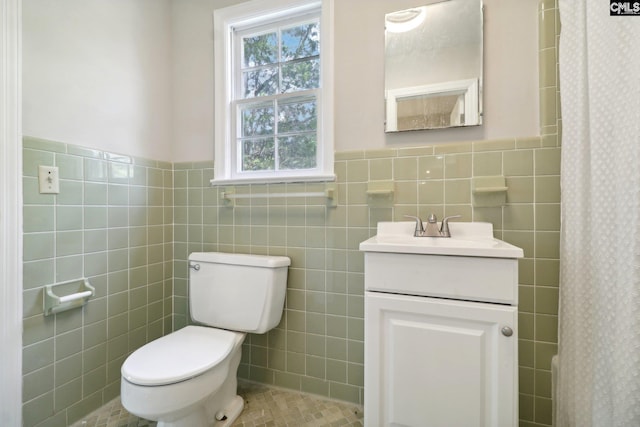 bathroom with tile walls, tile patterned flooring, vanity, and toilet