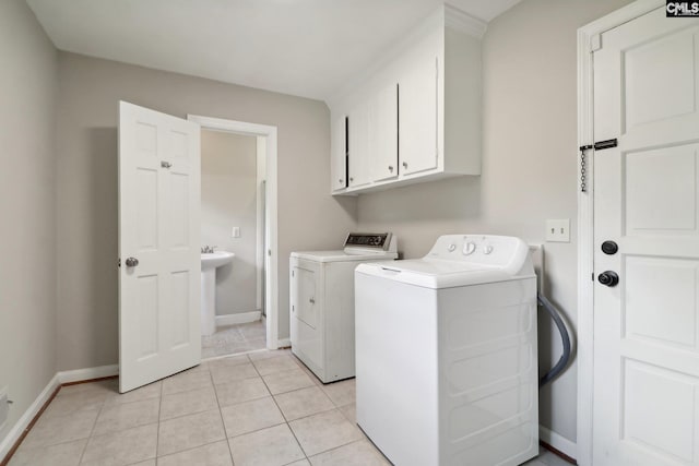 washroom featuring light tile patterned floors, cabinets, and independent washer and dryer