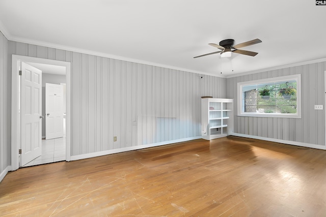 empty room with ceiling fan, light wood-type flooring, and crown molding