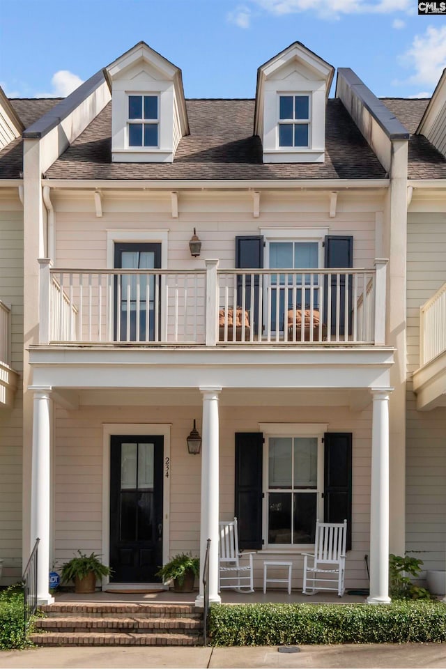 view of front facade with a balcony and covered porch