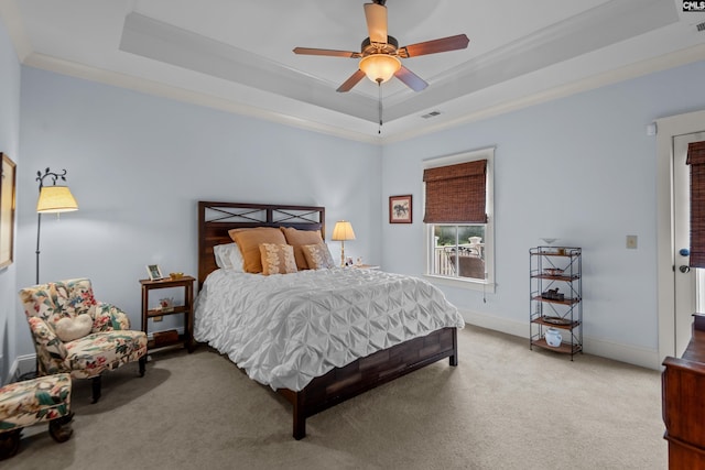 bedroom with ceiling fan, light colored carpet, a raised ceiling, and crown molding