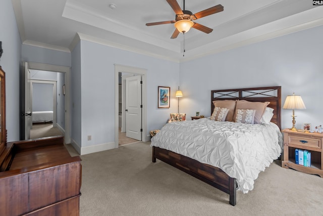 carpeted bedroom featuring ornamental molding, ceiling fan, and a raised ceiling