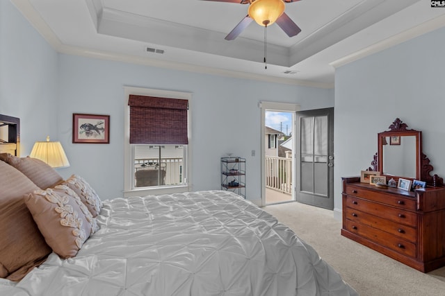 carpeted bedroom featuring access to outside, a tray ceiling, ceiling fan, and ornamental molding