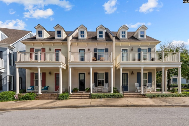 multi unit property featuring a balcony and covered porch