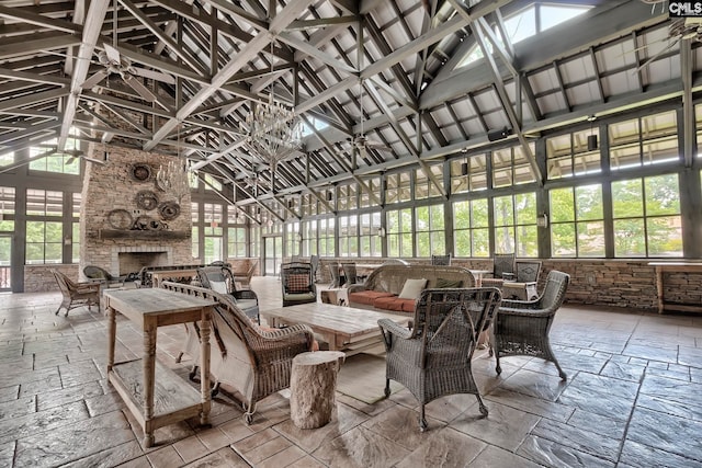 sunroom with a stone fireplace, vaulted ceiling, and a healthy amount of sunlight