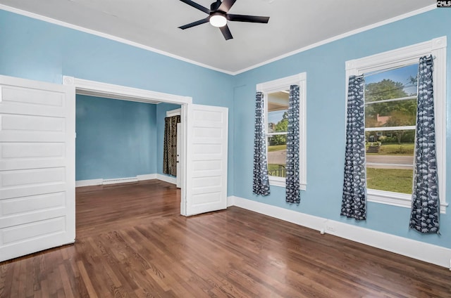 empty room with ceiling fan, crown molding, and dark wood-type flooring