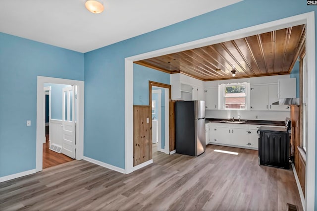 kitchen with stainless steel fridge, wood ceiling, white cabinetry, range, and light wood-type flooring