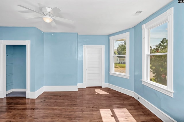 spare room featuring ceiling fan, plenty of natural light, and dark wood-type flooring