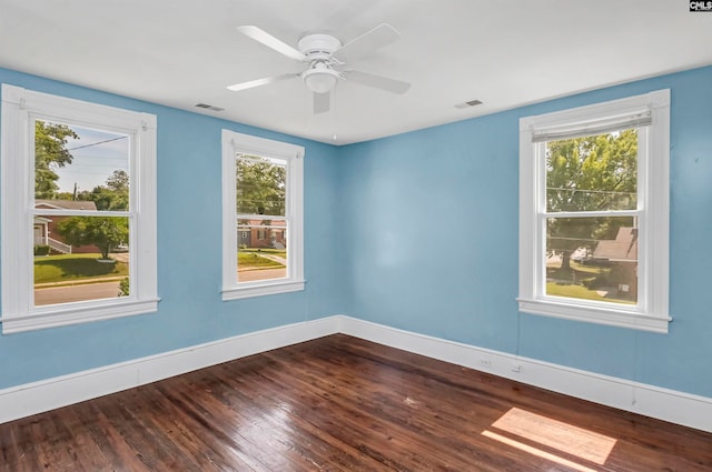 empty room with hardwood / wood-style flooring, ceiling fan, and plenty of natural light