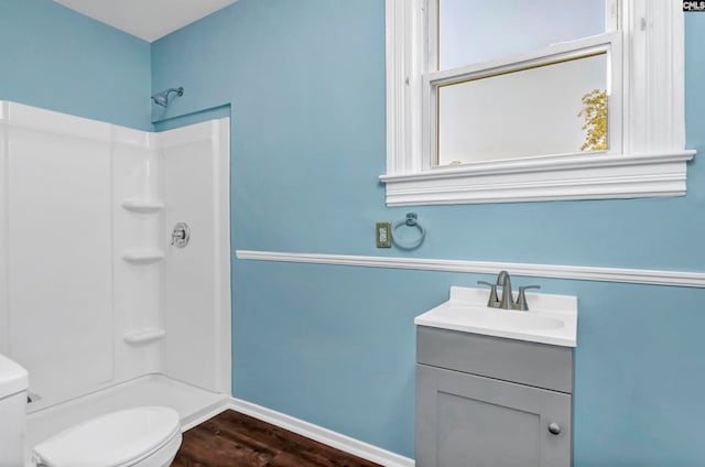 bathroom featuring a shower, vanity, and toilet