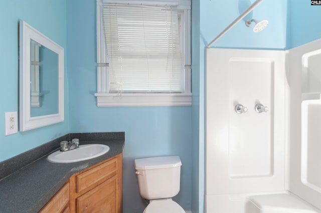 bathroom featuring a shower, vanity, and toilet