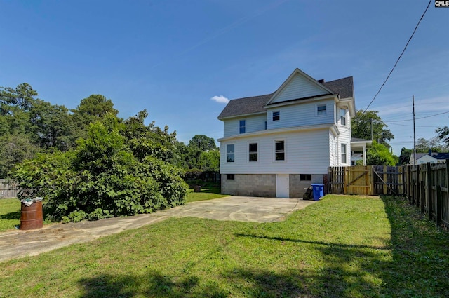 rear view of property featuring a lawn and a patio area