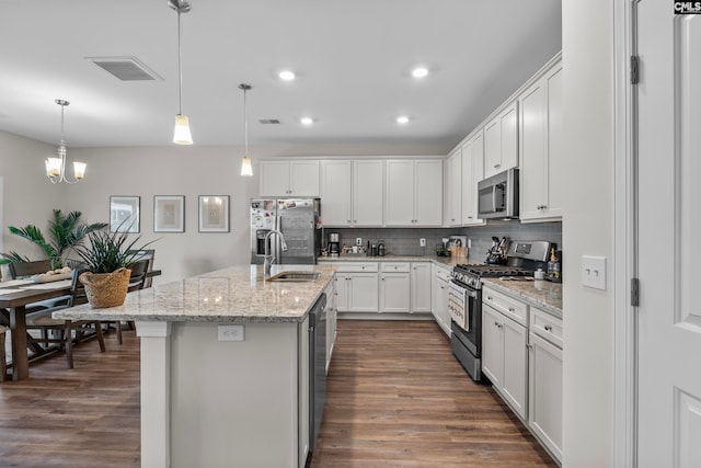 kitchen with appliances with stainless steel finishes, dark hardwood / wood-style floors, sink, and white cabinetry