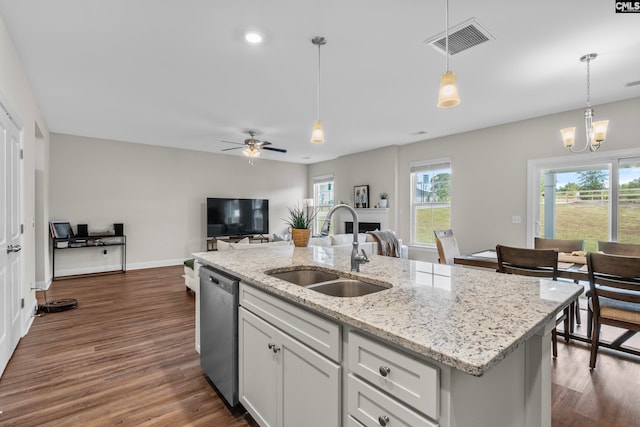 kitchen featuring ceiling fan with notable chandelier, stainless steel dishwasher, sink, and a wealth of natural light