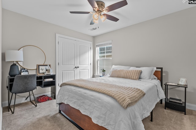 bedroom with ceiling fan, a closet, and light carpet