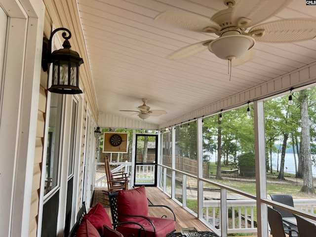 sunroom / solarium with lofted ceiling, a water view, ceiling fan, and plenty of natural light