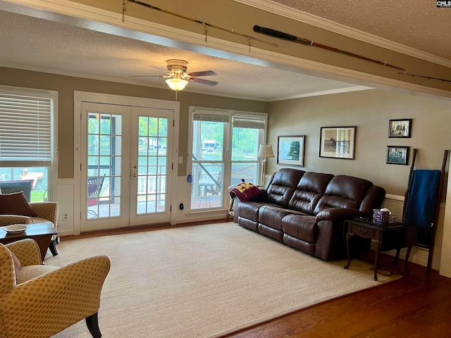 living room with a textured ceiling, crown molding, ceiling fan, french doors, and hardwood / wood-style floors