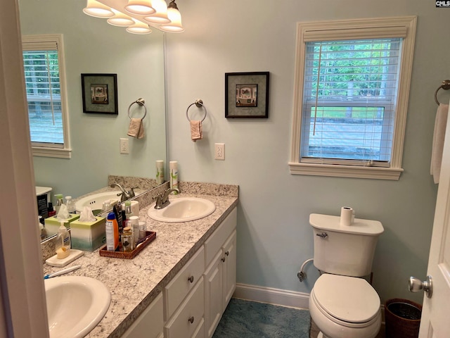 bathroom featuring vanity, plenty of natural light, and toilet