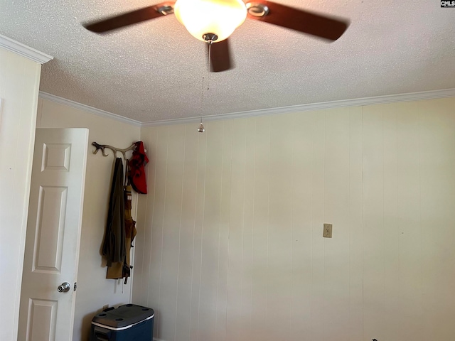 details featuring ceiling fan, a textured ceiling, crown molding, and wood walls