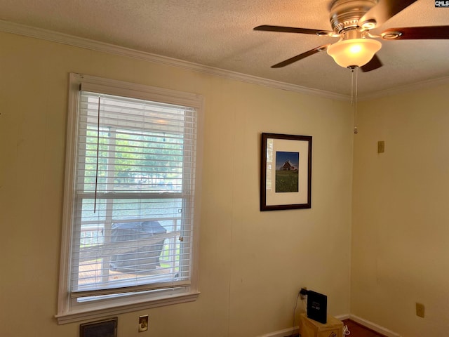 spare room featuring ceiling fan, a textured ceiling, and ornamental molding