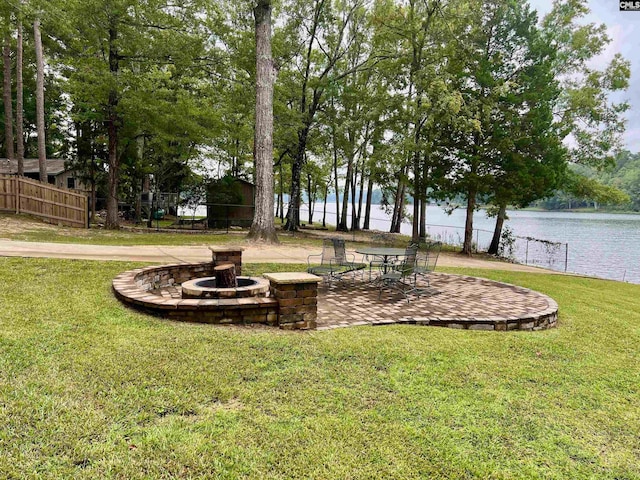 view of yard with a water view, an outdoor fire pit, and a patio area