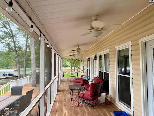 sunroom / solarium featuring ceiling fan