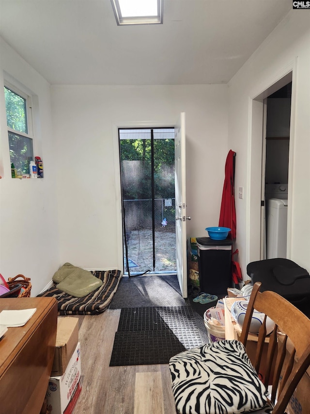 interior space with multiple windows, hardwood / wood-style flooring, access to exterior, and washer / clothes dryer