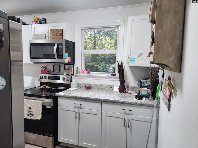 kitchen with white cabinetry, ornamental molding, light stone countertops, and appliances with stainless steel finishes