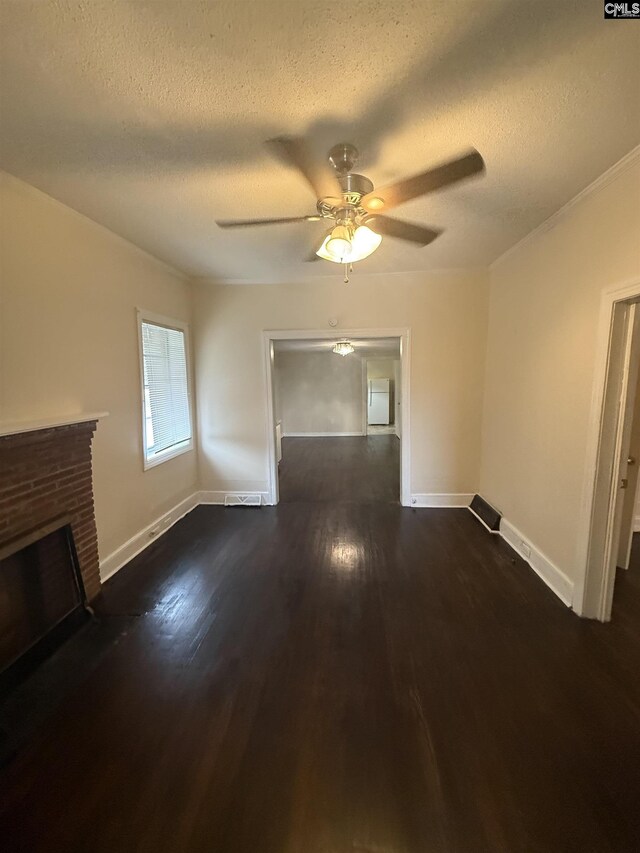 unfurnished living room with dark wood-type flooring, baseboards, a textured ceiling, a ceiling fan, and a fireplace