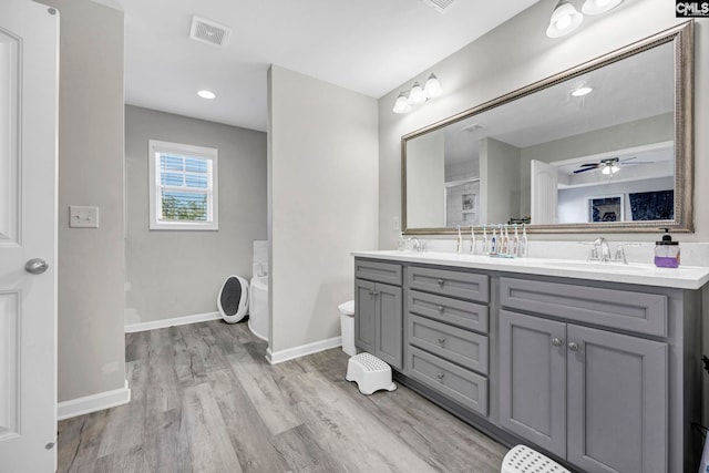 bathroom with ceiling fan, hardwood / wood-style flooring, vanity, and toilet