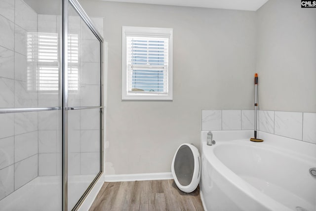 bathroom featuring wood-type flooring and separate shower and tub