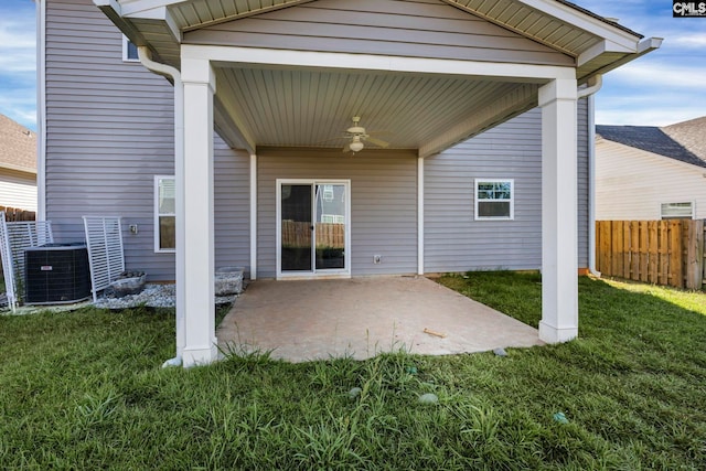 rear view of property with cooling unit, ceiling fan, a patio area, and a yard