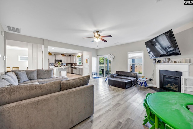 living room with light wood-type flooring and ceiling fan