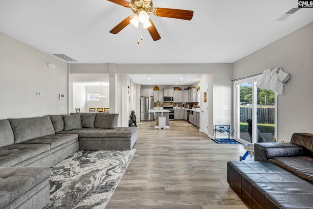 living room with ceiling fan and light hardwood / wood-style floors