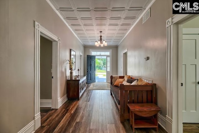 doorway with coffered ceiling, a notable chandelier, and dark hardwood / wood-style flooring