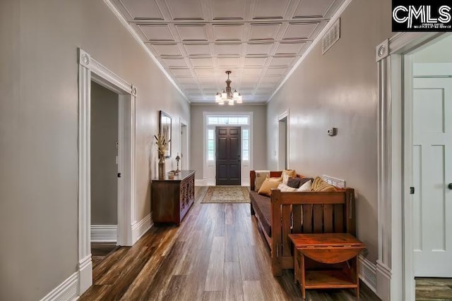 doorway to outside featuring a notable chandelier, coffered ceiling, and dark hardwood / wood-style flooring