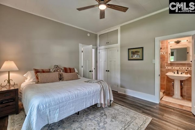 bedroom with ceiling fan, crown molding, connected bathroom, and wood-type flooring