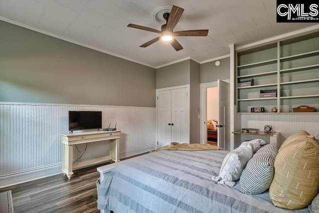 bedroom with ceiling fan, ornamental molding, wood walls, and dark hardwood / wood-style flooring