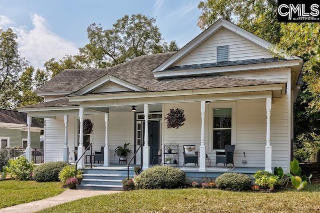 bungalow-style home with a front yard and covered porch