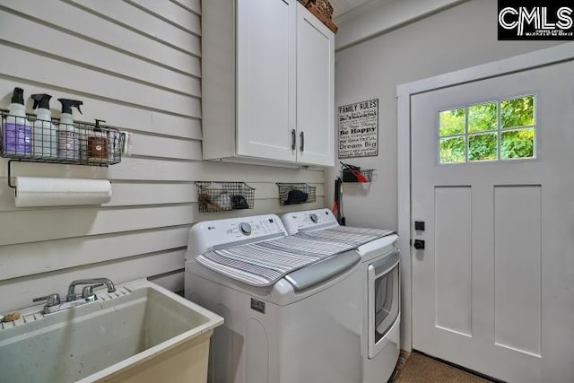 laundry area with separate washer and dryer, cabinets, and sink