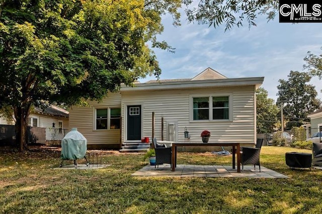 back of house with a patio and a yard