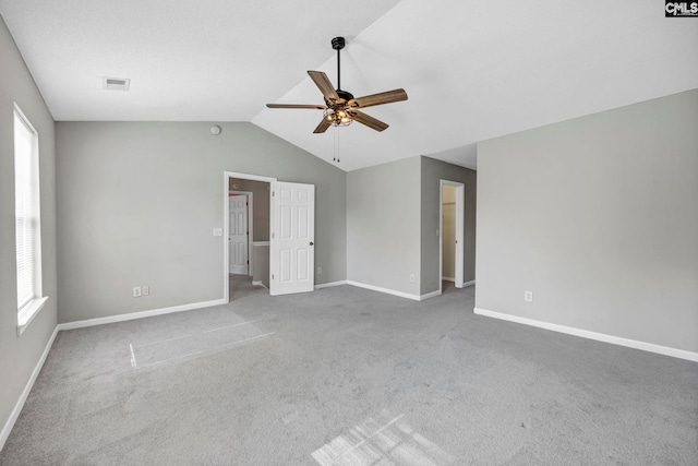 carpeted spare room with vaulted ceiling and ceiling fan