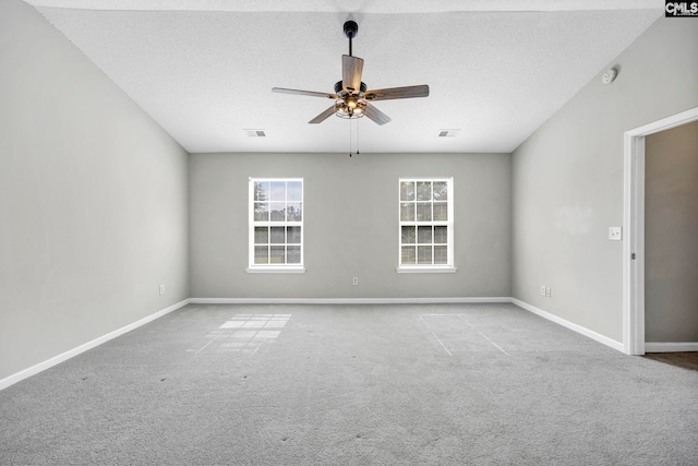 empty room with ceiling fan, a textured ceiling, and light carpet