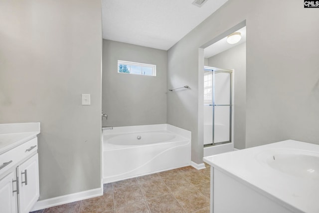 bathroom with independent shower and bath, vanity, tile patterned flooring, and a textured ceiling