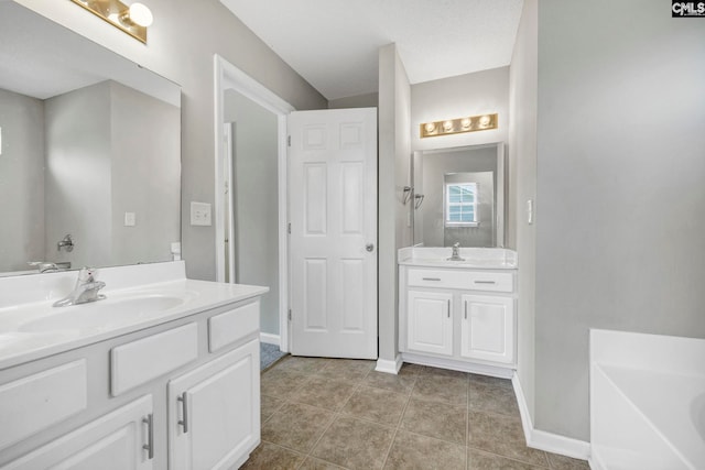 bathroom with vanity, a bathing tub, and tile patterned floors