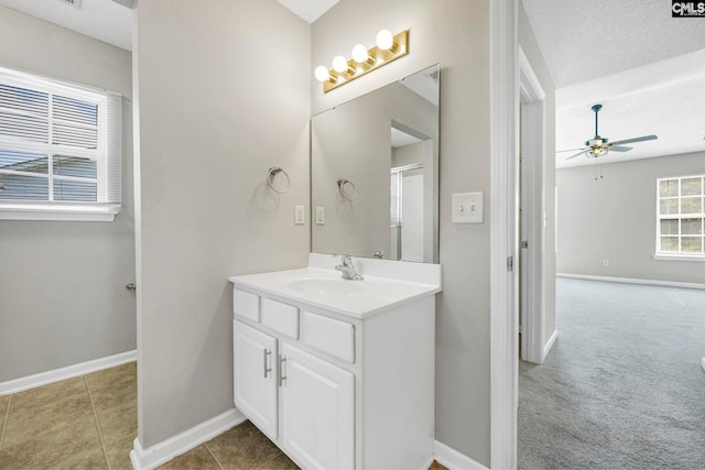 bathroom featuring tile patterned flooring, ceiling fan, vanity, and a textured ceiling