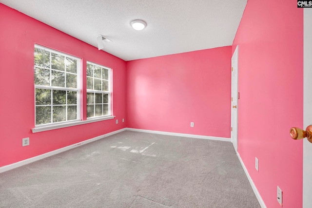 carpeted spare room with a textured ceiling