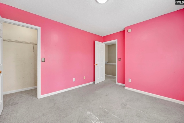 unfurnished bedroom with light colored carpet, a textured ceiling, and a closet