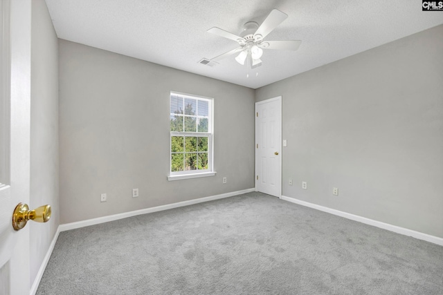 empty room with ceiling fan, carpet floors, and a textured ceiling